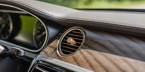 A wooden car air freshener on a vent, which can release chemicals that are bad for your health.