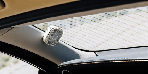 A car air freshener visor clip attached to a vehicle's sun visor.