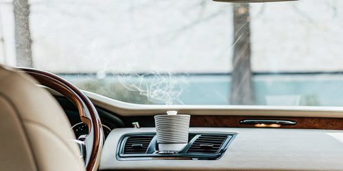 High end car air freshener clipped to an air vent inside a luxury car.