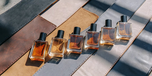 Top-rated leather colognes for men arranged on a textured leather surface.