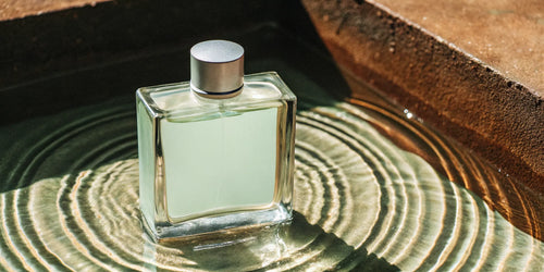 Fresh cologne for men in a glass bottle surrounded by clean, cool water.