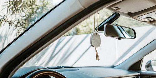 Sleek minimalist car air freshener hanging from a rearview mirror.